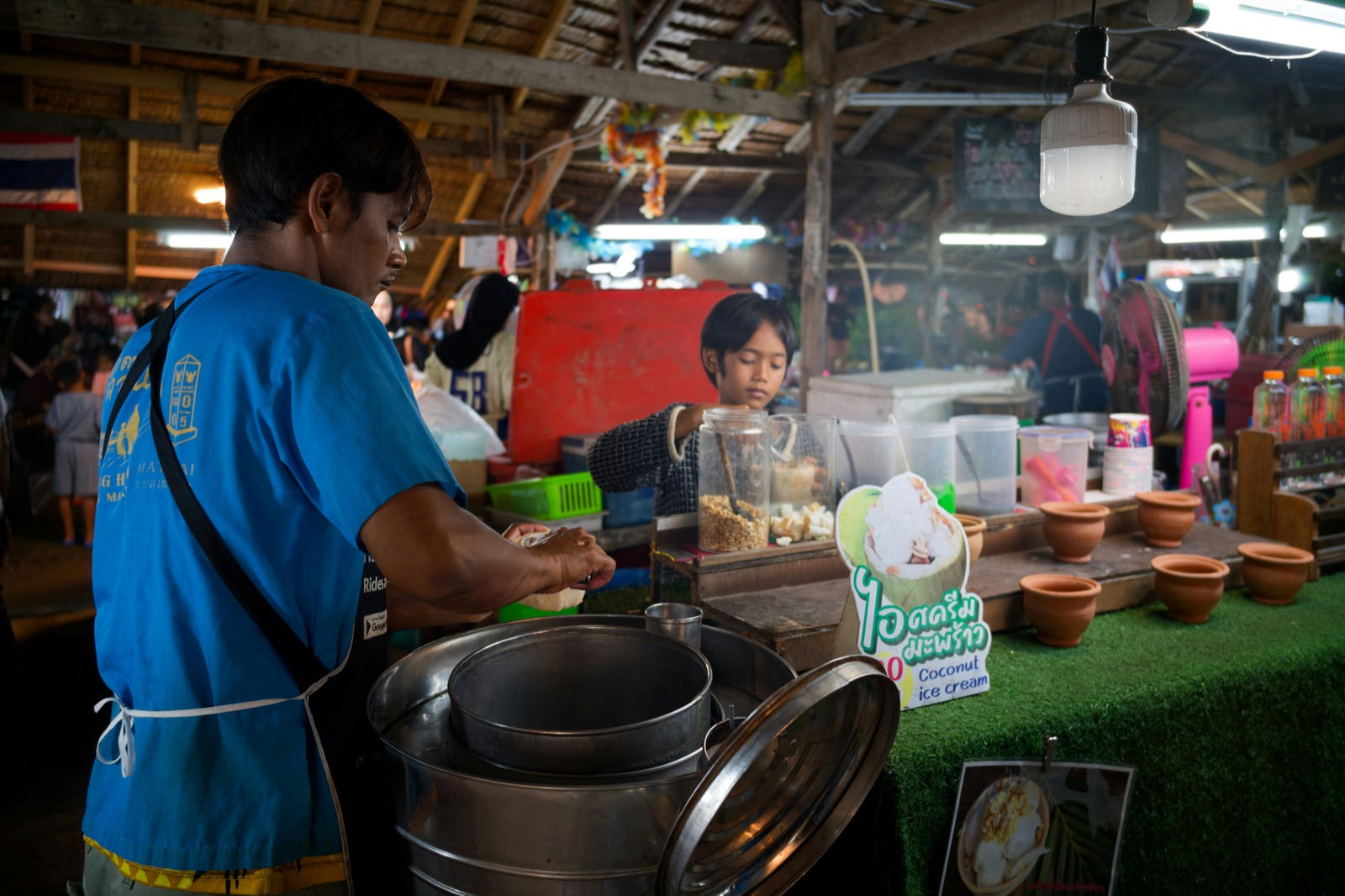 A family business preparing coconut ice cream at a night stall
